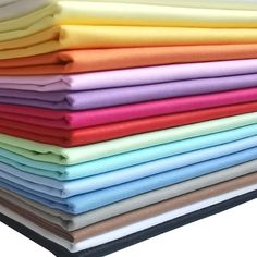 a stack of different colors of cloth on top of each other in various sizes and shapes