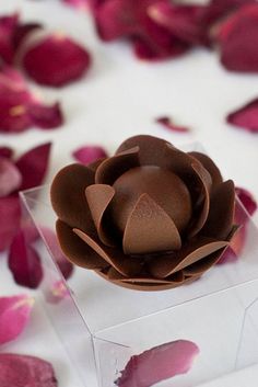 a chocolate flower sitting on top of a clear box