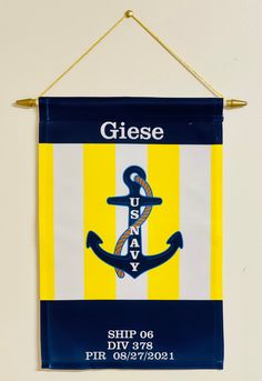 a blue and yellow flag with an anchor on it hanging from a hook in a wall