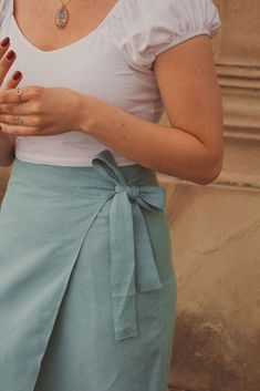 a woman wearing a white shirt and blue skirt