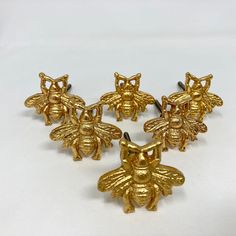 six gold bee brooches sitting next to each other