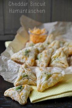 cheddar biscuits with hamantaaschen on a yellow napkin next to some chips