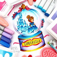 there is a snow globe with the name cinderella on it and some crayons next to it