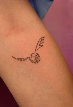 a small tattoo on the thigh of a woman's leg with a bird flying above it