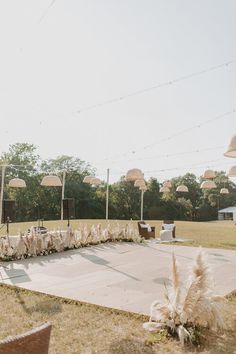 an outdoor area with tables, chairs and umbrellas in the background at a wedding