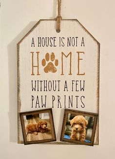 a house is not a home without a few paw prints hanging on a wall with two dogs