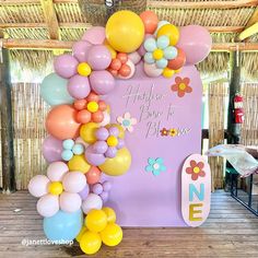 the balloon arch is decorated with flowers and balloons for a baby's first birthday