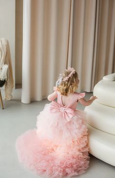 The Denise Girls Couture Ruffled Hi Lo Pageant Dress is a stunning choice for any young girl looking to make a statement on stage. This dress features a trendy hi-lo hemline, which pairs a shorter front with a flowing train in the back. The real showstopper, though, is the abundance of ruffles that cascade down the skirt. These layers of gathered tulle add volume, movement, and an undeniable touch of drama. The dress is available in a variety of colors, allowing your little princess to choose the hue that best matches her personality. Whether she's competing in a natural pageant or a glitz event, this dress is sure to turn heads. Pair it with some sparkly accessories and she'll be the belle of the ball. PLEASE NOTE: Most of the time these dresses would be in stock locally and available to Natural Pageant, Pageant Mom, Baby Christening Outfit, Girls Communion Dresses, Sparkly Accessories, Flower Girl Crown, Girls Couture, Christening Outfit, Girls Pageant Dresses