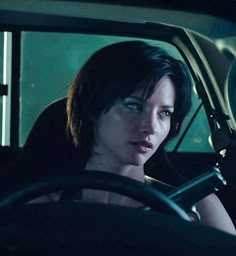 a woman sitting in the driver's seat of a car