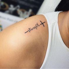 a woman with a cross tattoo on her arm that says strength above the word strength