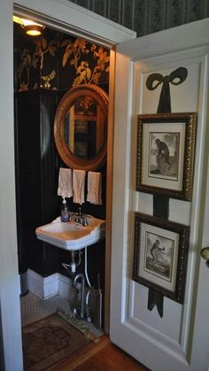 an open door leading to a bathroom with pictures on the wall and sink in it