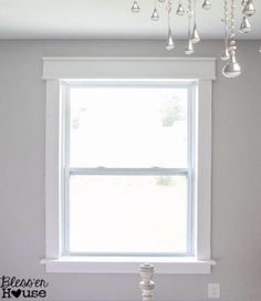 a white window with chandelier hanging from it's side in a room