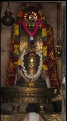 the statue is decorated with flowers and garlands