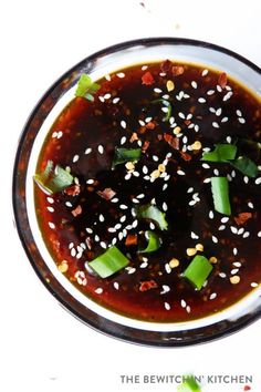 an overhead view of a bowl of food with sesame seeds and green onions in it