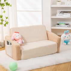 two stuffed animals sitting on a couch in a living room