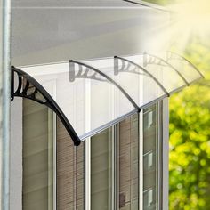 an awning is hanging from the side of a house in front of some windows