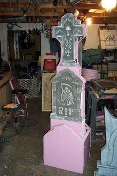 a pink and grey tombstone with a skeleton on it in a garage area next to other furniture