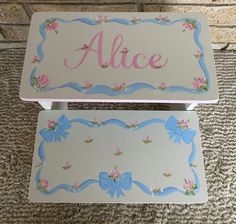 two children's personalized step stools with flowers and bows on the sides