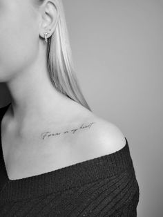 a woman with a small tattoo on her neck saying, fear or hope in cursive writing