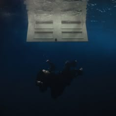 a person floating in the water with their feet on an object that looks like a box