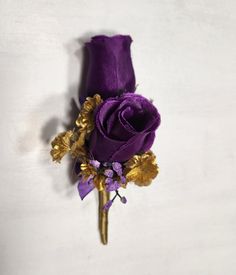 a purple and gold boutonniere on a white background