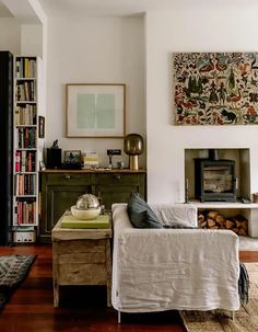 a living room filled with furniture and a fire place next to a book shelf full of books