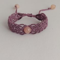 This bracelet is meticulously crafted using the macrame technique, featuring agate beads and polyester thread. Reflecting the boho hippie style, this bracelet stands out with its 2 cm width and 16 cm length woven part. With a total length of 30 cm, it fits any wrist thanks to its adjustable sliding lock. This stylish and comfortable bracelet is the perfect accessory to complete your look. Adjustable Round Beads Jewelry For Gifts, Spiritual Macrame Bracelets As Gift, Spiritual Macrame Bracelet As Gift, Bohemian Pink Agate Bracelets, Macrame Bracelet Jewelry As Gift, Macrame Bracelet Jewelry Gift, Artisan Beaded Macrame Bracelet As Gift, Artisan Beaded Bracelets With Macrame For Gift, Handmade Adjustable Round Bracelets