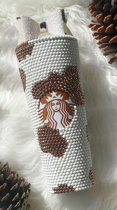 the starbucks cup is made out of beads and other things that are on top of white fur