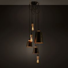 a group of lights that are hanging from a light fixture in a room with dark walls