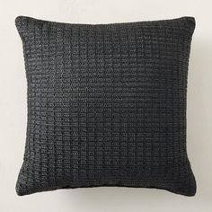 a black pillow on a white wall