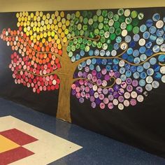 an art project is displayed on the wall in front of a school room with buttons painted on it