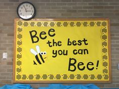 a bulletin board with a bee on it next to a clock