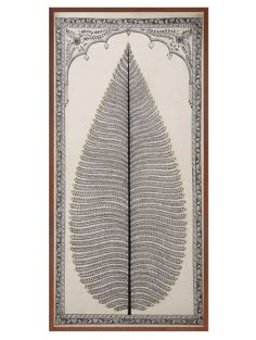 an intricately designed leaf is displayed in a wooden frame