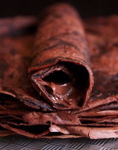 a rolled up chocolate pastry sitting on top of a table