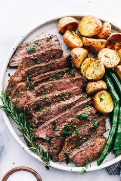 a white plate topped with steak, potatoes and green beans