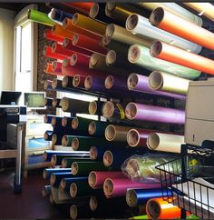 a room with many rolls of colored paper hanging from the ceiling