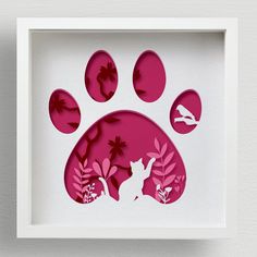 an animal's paw is cut out from paper and placed in a white frame