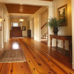 an empty hallway with wood floors and white walls, along with a wooden table in the center