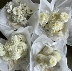 four bouquets of white flowers sitting on top of each other