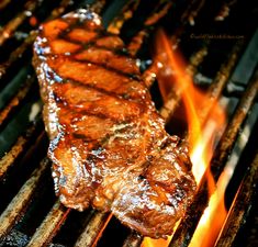 steak cooking on the grill with flames coming from it