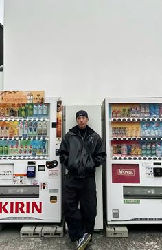 a man standing next to two vending machines