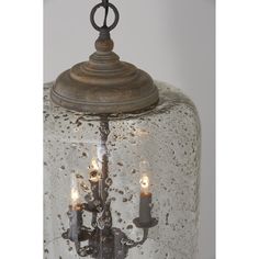 an old fashioned glass light fixture with three candles