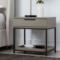 a table with a drawer and a vase on it next to a couch in a living room