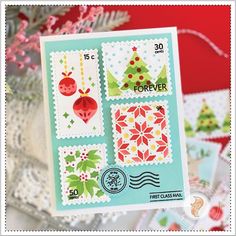 a christmas card with stamps on it next to a tree and other holiday decorations in the background