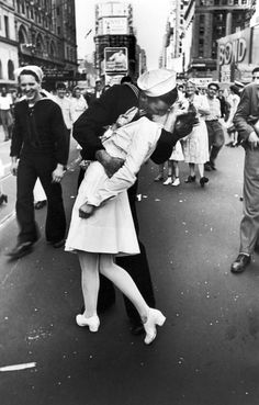 a man kissing a woman on the cheek in front of a group of people, with text that reads i miss you so