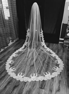 a bride's veil is seen in this black and white photo from the back