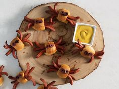 some food is on a wooden plate with sauce in the middle and little octopus heads sticking out of it