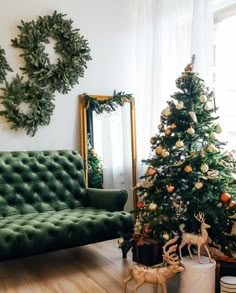 a living room decorated for christmas with green velvet sofa