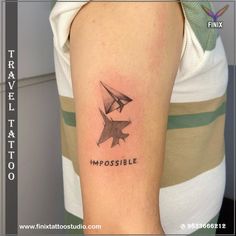 a woman with a tattoo on her arm that says impossibleible and an origami bird