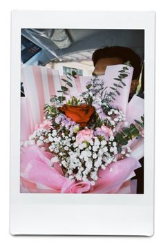 a bouquet of flowers sitting on top of a pink ribbon in the back seat of a car